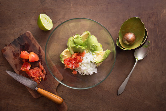 Preparing homemade guacamole on wooden table