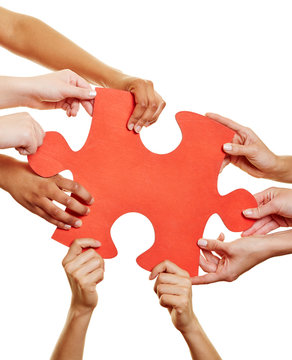 Hände halten Puzzle als Symbol für Teamwork