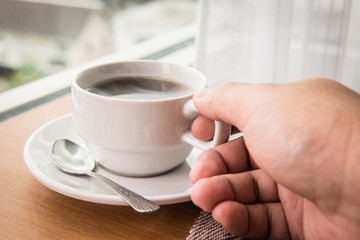 holding hot cup of coffee