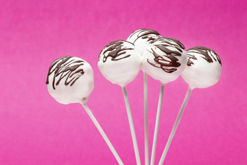 Chocolate cake pops on pink background