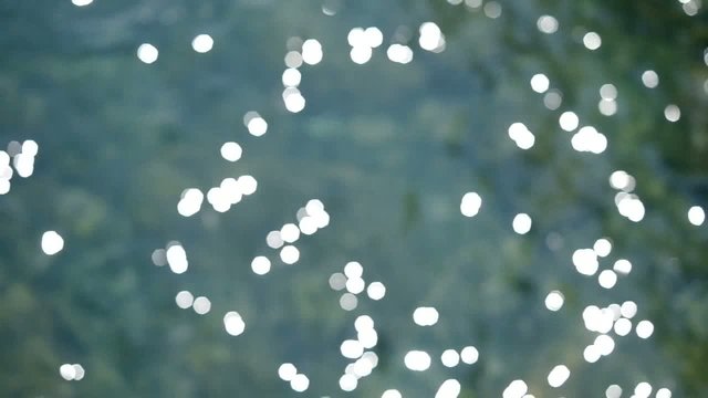 sunlight reflections sparkling on water with oily surface