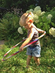 young girl playing hulahup