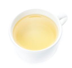 White cup of green organic tea on white background