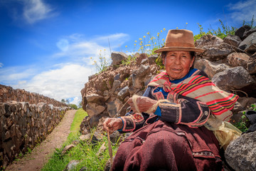 Peruvian Indian Woman in Traditional Dress Weaving - obrazy, fototapety, plakaty