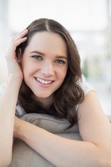 Obraz premium Close up on smiling cute woman lying on a cosy couch