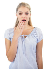 Shocked blonde woman with hand in front of her mouth