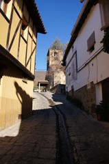 Fototapeta na wymiar Typowa ulica, stromy stok, droga wodna na ulicy, wieża kościoła