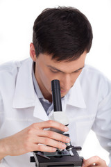 Scientist. Confident young man looking through microscope while