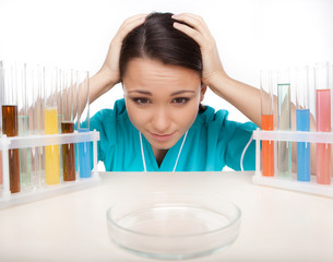 Frustrated young scientist. Disappointed young woman in lab coat