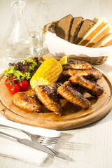 chicken wings are grilled on a wooden platter