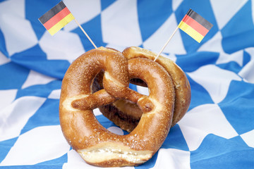 Laugenbrezel mit Deutschlandfahne auf einer bayerischen Fahne