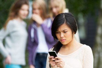 Teenage Girl Being Bullied By Text Message On Mobile Phone