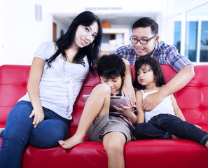 Happy family enjoy relaxing time on red sofa at home
