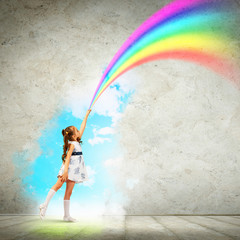 Little girl drawing rainbow