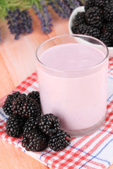 Sweet blackberries with yogurt on table close-up