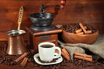 Coffee cup and metal turk on wooden background
