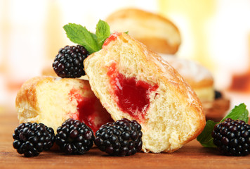 Tasty donuts with berries on wooden table
