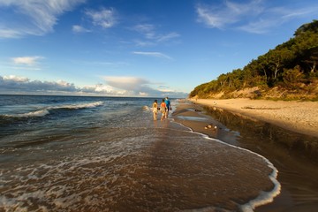 młodzi ludzie spacerują brzegiem morza 
