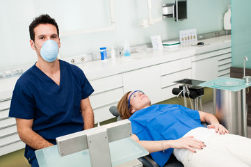 Dentist in his surgery. In the background we can see the patient