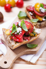 sandwich with red, yellow and black tomatoes and feta cheese