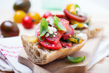 sandwich with red, yellow and black tomatoes and feta cheese - obrazy, fototapety, plakaty