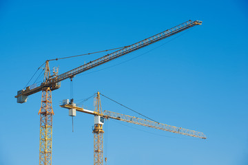 tower cranes over blue sky