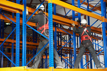 two warehouse workers installing rack arrangement