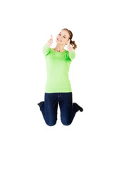 Young happy caucasian woman jumping in the air with thumbs up