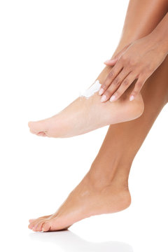 Female hands treating feet with moisturizing cream