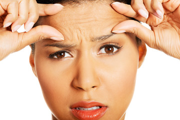 Woman checking her wrinkles on her forehead