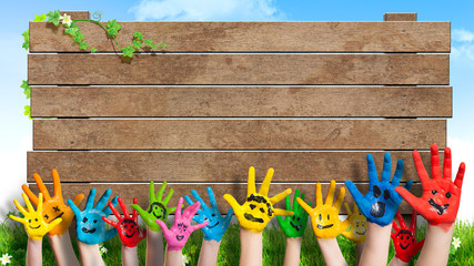 lanchende Kinderhände vor Holzschild