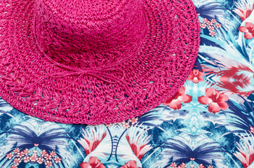 Pink Straw Hat on a Piece of Colorful Fabric
