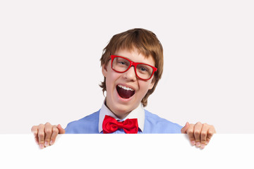 Boy in red glasses holding white square