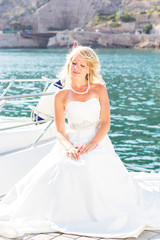Fototapeta na wymiar Beautiful bride posing near the sea