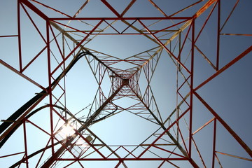 looking up inside a metal pylon tower with geometrical pattern of triangles