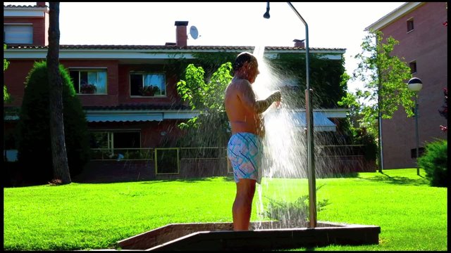 hombre duchandose en el jardin