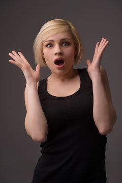 Shocked woman. Surprised young woman gesturing while isolated on