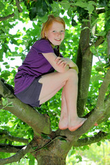 Junges Mädchen sitzt im Baum