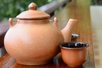 Teapot and double teacup on brown tablecloth