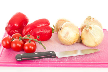 Peppers onions and tomatoes on chopping board