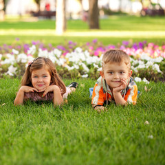 Fototapeta na wymiar Little boy and girl relaxing on the grass