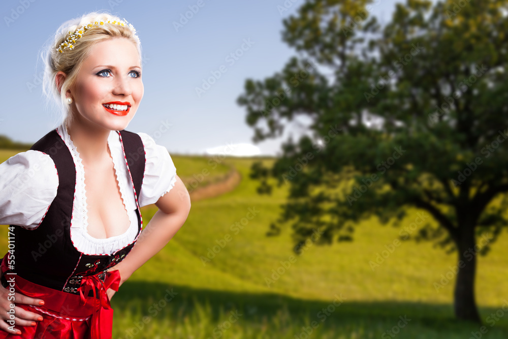 Wall mural junge Frau im Dirndl vor ländlichem Hintergrund