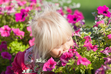 Fototapeta premium Cute little girl smells flowers