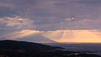 Divine light, stormy sky and sunrise around holy mountain Athos