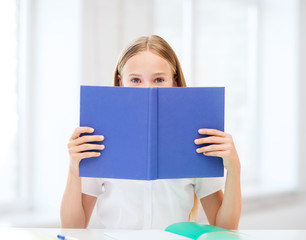 girl studying and reading book at school