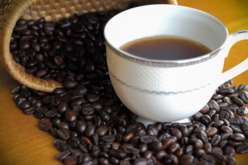 Coffee cup and coffee bean on a wooden table