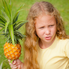 happy little girl holding in hands  a pineapple