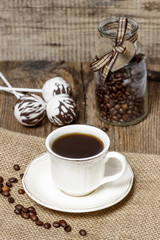 Cup of coffee on hessian napkin. Coffee beans around. Selective