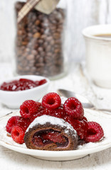 Swiss roll (roulade) with raspberries on white plate. Selective