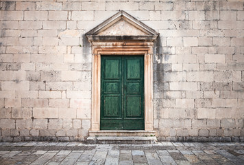 Stone wall with green wooden door